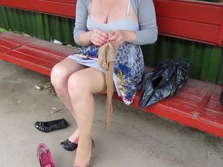Girl put on stockings on bus stop