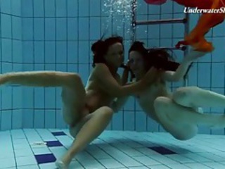 Two beautiful girls swim in a difficulty empty tubes